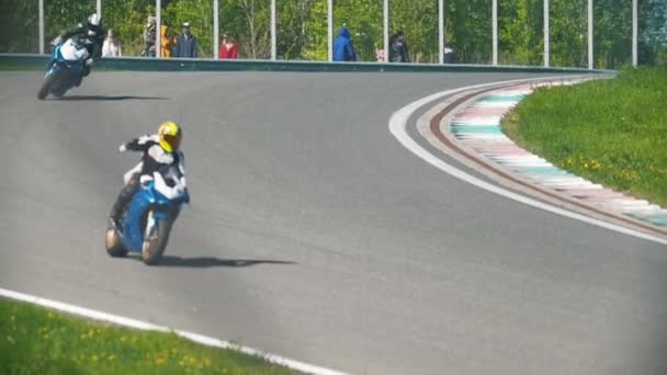 Três motociclistas na corrida estão dirigindo em uma volta, câmera lenta — Vídeo de Stock