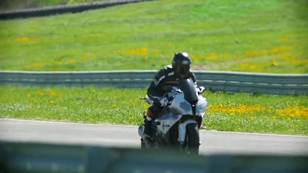 Мотоспорт - мотоциклист на красном мотоцикле едет по полосе, замедленное движение — стоковое видео