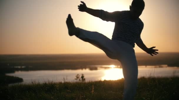 Le combattant fait un handstand sur le fond du soleil couchant, au ralenti — Video
