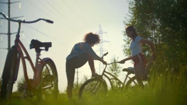Genç bisikletçi, bacaklar esneme arka planda içme suyu kız