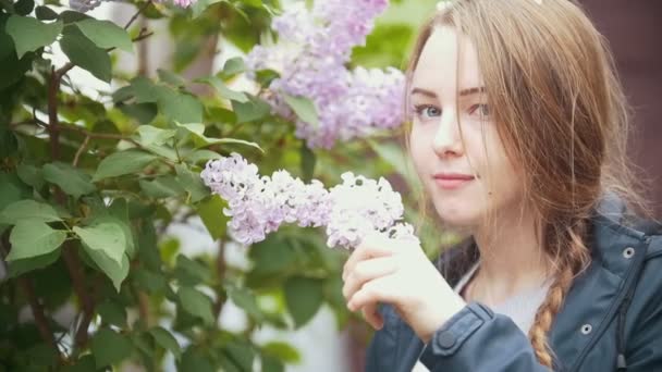 Bloeiende lila, genieten van de geur van bloemen meisje — Stockvideo