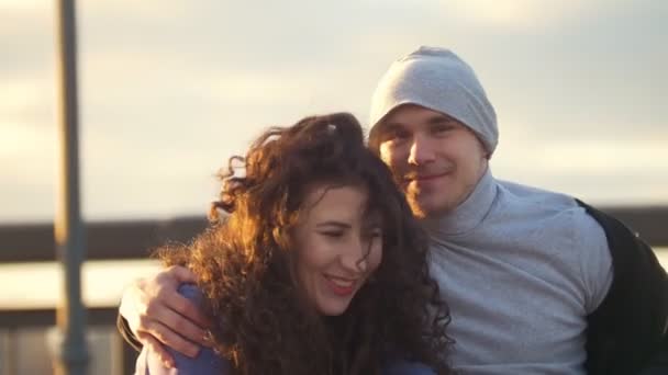 Porträt eines glücklichen Paares - behinderter Mann im Rollstuhl im Gespräch mit attraktiver junger Frau, die den Sonnenuntergang genießt — Stockvideo