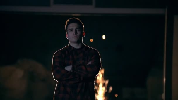 Portrait of young man stands among the flying sparks from grinder — Stock Video