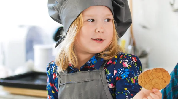 Маленькая девочка пекарь держит в руках домашнее печенье — стоковое фото