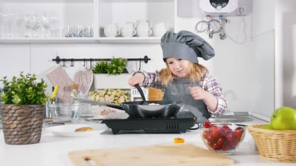 Esikoulu pieni tyttö leipuri tekee evästeitä iso pannulla — kuvapankkivideo