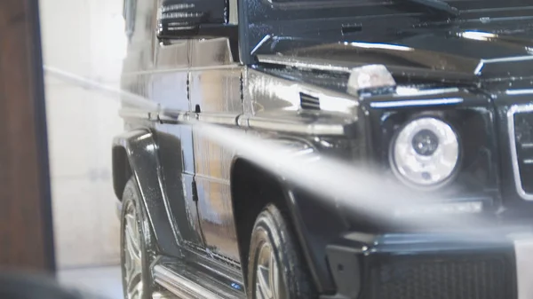 Lavado del coche SUV en las suds por mangueras de agua en servicio automático - taller de vehículos — Foto de Stock