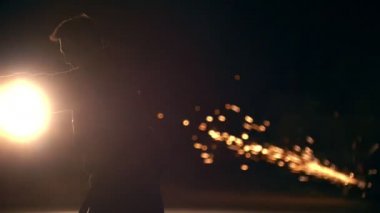Dövüş öğeleri kıvılcımlar boyunca performans adam silüeti takla, yavaş hareket değirmeni gece - arka