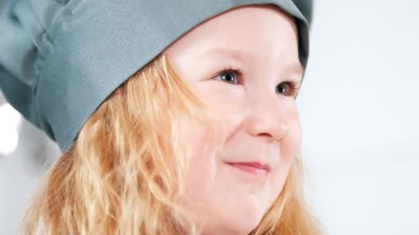 Porträt eines kleinen Mädchens, das als Koch verkleidet mit einem Schneebesen wedelt — Stockvideo