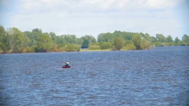 Vliegende kite surfer op het kiteboard over de brede rivier — Stockvideo