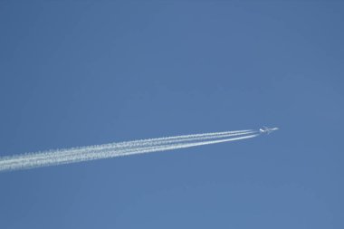 Beyaz uçak mavi Berrak gökyüzü beyaz contrails çekerek