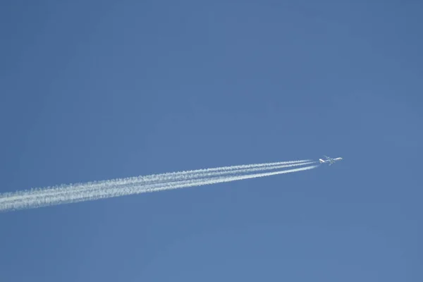 Aereo bianco tirando bianco contrae nel cielo blu chiaro — Foto Stock