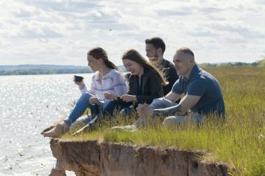 Mutlu arkadaş eğlenmek üstünde belgili tanımlık tepe eğlence keyfini ve konuşurken Nehri üzerinde