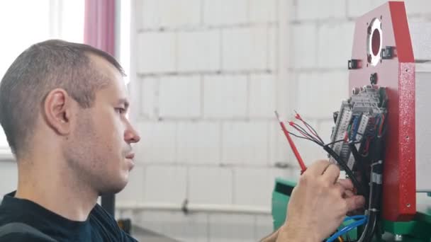 Retrato de electricista en mono está trabajando con panel de energía y equipos de maquinaria en planta — Vídeos de Stock