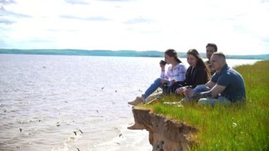 Neşeli arkadaşları doğa nehrin arka plan üzerinde hafta sonu zevk Hill'de oturan