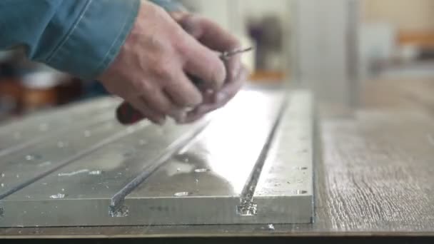 Manos masculinas biselando la eliminación de rebabas en detalle de metal para la fabricación de maquinaria cnc con un raspador — Vídeos de Stock