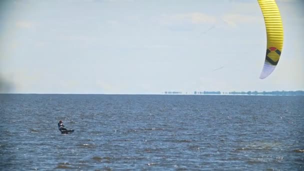 Adam bir kitesurf üzerinde bir yelken ile su üzerinde hareket — Stok video