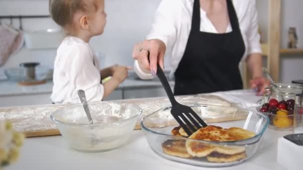 Cute mom with her little daughter cooking cottage cheese pancakes — Stock Video