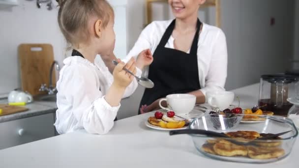 Gelukkig moeder en dochter drink thee met huisgemaakte pannenkoeken — Stockvideo