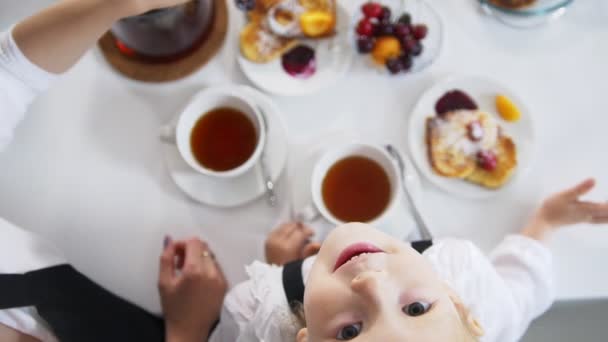 Felülnézet anya és vele a kis lányom a tea idő eszik gyümölcsöt — Stock videók