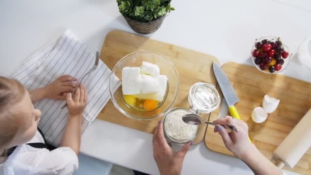 Mutter mit Tochter legt Mehl in den Teig für Quark-Pfannkuchen — Stockvideo