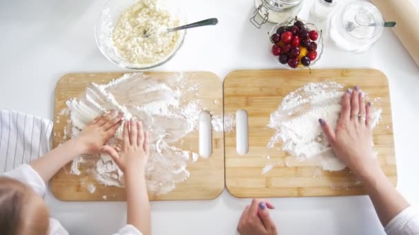 Mamá y su hija espolvorean harina en el tablero para preparar panqueques — Vídeo de stock