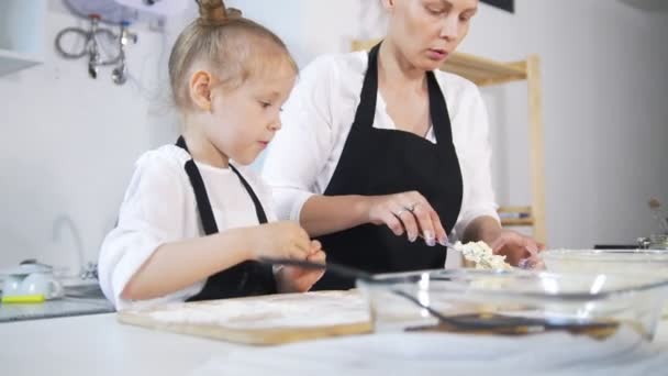 Mother and her little daughter forms cottage cheese pancakes — Stock Video