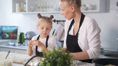 Küçük beyaz kız annesiyle birlikte mutfakta yemek