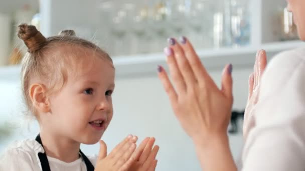 Felice bambina con sua madre applaudire le mani in cucina — Video Stock