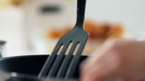 Vrouwelijke handen klapt kwark pannenkoeken in een koekenpan — Stockvideo