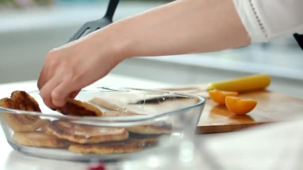 Female hands pulls out of a plate freshly cooked pancakes — Stock Video