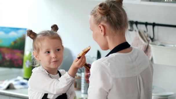 Gelukkig dochtertje met moeder eet huisgemaakte pannenkoeken — Stockvideo