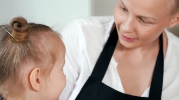 Fröhliches kleines Mädchen mit ihrer Mutter, die mit Mehl spielt — Stockvideo