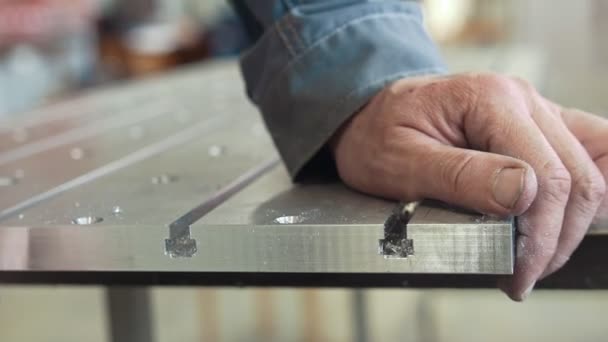 Mãos masculinas chanfrando removendo rebarbas em detalhes de metal para a fabricação de máquinas cnc com um raspador — Vídeo de Stock