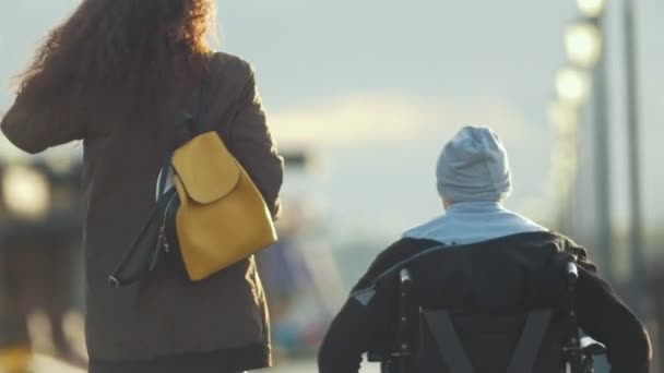 車椅子の障害者男性が岸壁には若い女性の写真を撮る — ストック動画