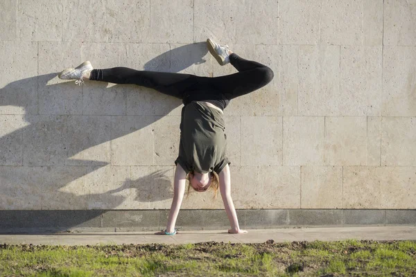 Giovane manubrio femminile contro il muro esegue elementi acrobatici — Foto Stock