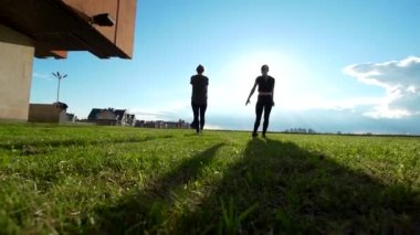İki erkek jimnastikçi bir backflip açık havada yaz gün batımında gerçekleştirir