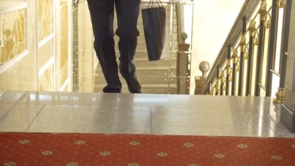 İş ofis binası içinde merdivenlerden yukarı tırmanma takım elbiseli adamı — Stok video