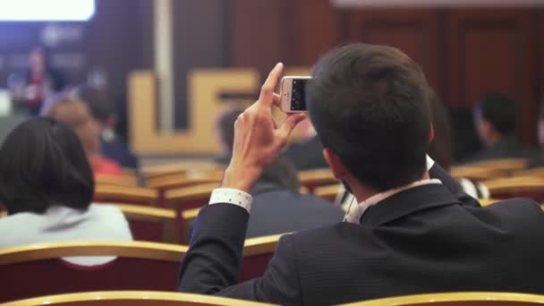 Vista trasera del joven toma foto de la ceremonia de entrega de premios — Vídeos de Stock