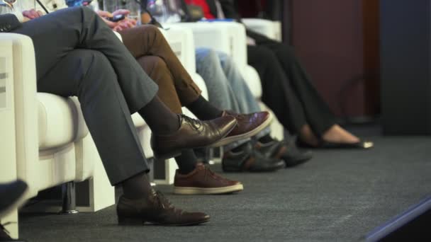 Beine von Menschen, die auf der Wirtschaftskonferenz sprechen