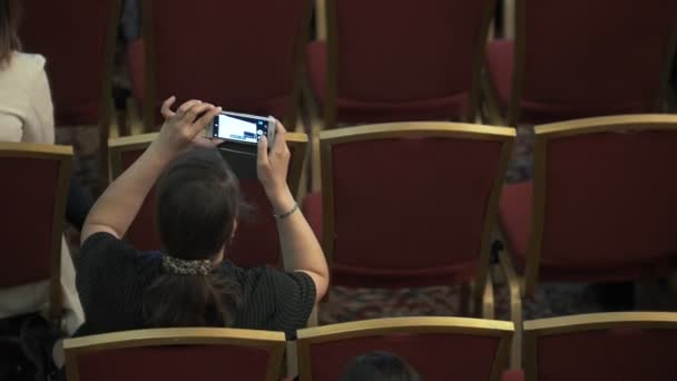 Rückansicht einer Frau, die bei der Preisverleihung am Telefon schießt — Stockvideo