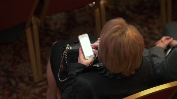 Vue du dessus de la femme avec smartphone assis à la conférence d'affaires — Video