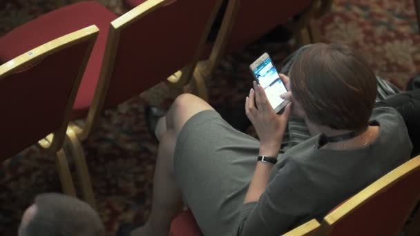 Vista dall'alto della giovane donna che chatta sullo smartphone alla conferenza aziendale — Video Stock