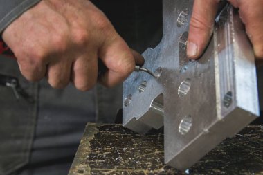 Eller çalışma erkek metal ayrıntılı bir sıyırıcı biler.