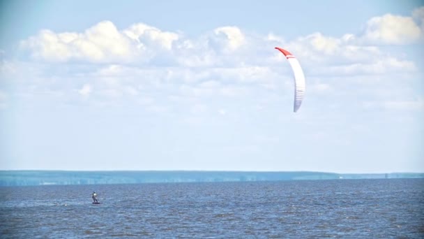 Hombre kitesurfer en el tablero volando en el río con vela — Vídeos de Stock