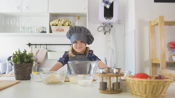 Портрет маленькой девочки-пекаря на кухне — стоковое фото