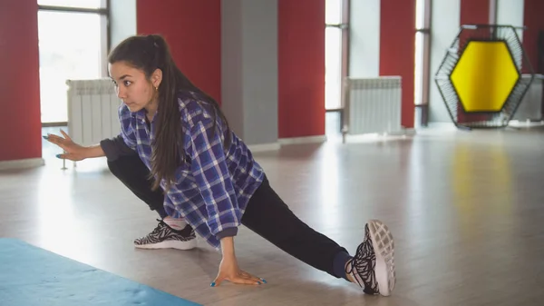 Attraktive weibliche Brünette Stretching im Fitnessraum — Stockfoto