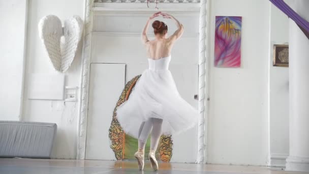 Unga attraktiva ballerina i vitt tutu utför pirouette i rymlig studio — Stockvideo