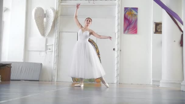 年轻漂亮的芭蕾舞演员在白色的芭蕾舞短裙摆在宽敞的白色工作室 慢动作 — 图库视频影像