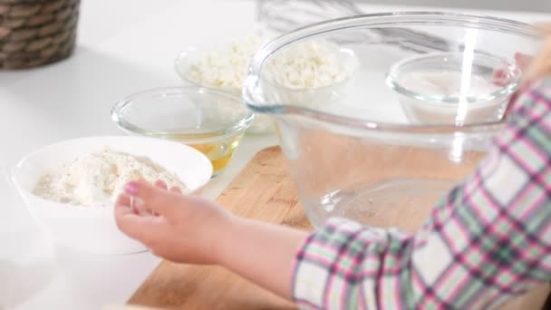 Niños manos de niña apuntando a cuencos de vidrio con ingredientes para cocinar panqueques de queso cottage — Vídeos de Stock