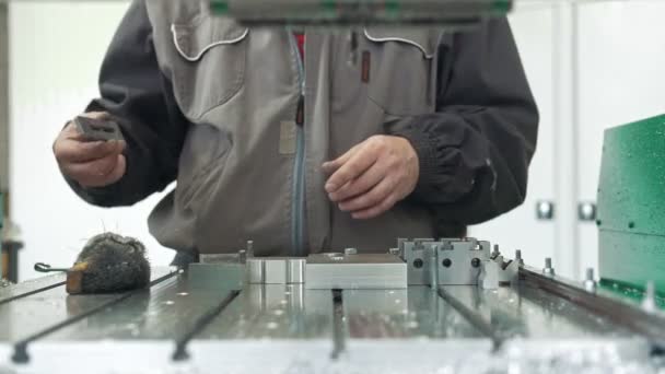 Arbeiter mit einem Schaber, der Grate auf Metallgegenständen entfernt, um industrielle CNC-Maschinen herzustellen — Stockvideo